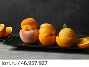 Тарелка с вкусным мороженым в апельсиновых корках на сером фоне. Стоковое фото, фотограф Pixel_shot / Фотобанк Лори
