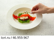 Женщина украшает тарелку вкусной рыбы сибас с тимьяном на светлом фоне. Стоковое фото, фотограф Pixel_shot / Фотобанк Лори