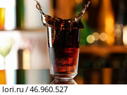 Стакан вкусного коктейля Cuba Libre с брызгами на столе на размытом фоне. Стоковое фото, фотограф Pixel_shot / Фотобанк Лори