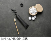 Черная зубная паста с активированным углем, щеткой и ватными тампонами на темном фоне. Стоковое фото, фотограф Pixel_shot / Фотобанк Лори