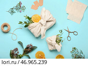 Композиция с подарочными коробками, обернутыми тканью, веревкой, ножницами и цветочным декором на синем фоне. Стоковое фото, фотограф Pixel_shot / Фотобанк Лори