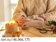 Женщина с подарочной коробкой, обернутой тканью и декором, за столом, крупным планом. Стоковое фото, фотограф Pixel_shot / Фотобанк Лори