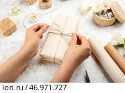 Женщина упаковывает подарочную коробку на фоне гранж, крупным планом. Стоковое фото, фотограф Pixel_shot / Фотобанк Лори