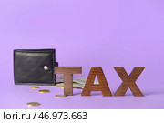 Слово НАЛОГ и бумажник с деньгами на цветном фоне. Стоковое фото, фотограф Pixel_shot / Фотобанк Лори
