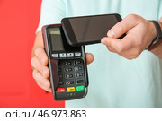 Человек с платежным терминалом и мобильным телефоном на цветном фоне, крупным планом. Стоковое фото, фотограф Pixel_shot / Фотобанк Лори