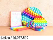 Тетрадь с текстом ЧТО ТАКОЕ АУТИЗМ? и хлопай игрушками на цветном фоне. Стоковое фото, фотограф Pixel_shot / Фотобанк Лори