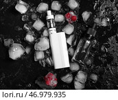 Современный вейп-мод, ягоды и кубики льда на черном фоне. Стоковое фото, фотограф Pixel_shot / Фотобанк Лори