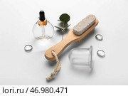 Композиция с бутылкой эфирного масла, пемзой и вакуумной банкой для антицеллюлитного массажа на белом фоне. Стоковое фото, фотограф Pixel_shot / Фотобанк Лори