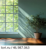 Minimalist and harmonious interior composition. The frame shows a corner of a room with a large window through which sunlight penetrates, casting soft shadows on the wall and floor. The view outside the window shows blurred silhouettes of green leaves on the trees, creating a sense of calm and connection with nature. On the right side of the image is a large houseplant in a simple ceramic pot, harmoniously fitting into the interior. The color scheme is maintained in natural tones: green, warm wood and muted gray-blue. Стоковое AI-изображение, AI-художник Анна Кривицкая / Фотобанк Лори