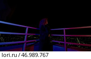 Fashion woman in coat and glasses stands on roof of high-rise building. Стоковое фото, фотограф David Kashakhi / Фотобанк Лори