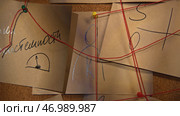Flashlight illuminates secret notes on board with threads. Стоковое фото, фотограф David Kashakhi / Фотобанк Лори