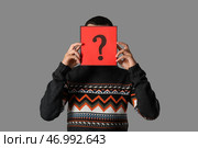 Молодой человек, держащий бумагу с вопросительным знаком на сером фоне. Стоковое фото, фотограф Pixel_shot / Фотобанк Лори