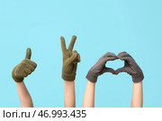 Руки в теплых перчатках жестикулируют на голубом фоне. Стоковое фото, фотограф Pixel_shot / Фотобанк Лори