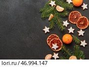 Звездообразное имбирное печенье с мандаринами, сушеным апельсином и ветвями ели на черном фоне. Стоковое фото, фотограф Pixel_shot / Фотобанк Лори