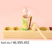 Розетка с деньгами, лампочкой и вилкой на розовом фоне. Концепция счетов за электроэнергию. Стоковое фото, фотограф Pixel_shot / Фотобанк Лори