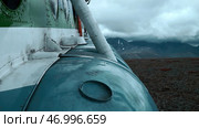 Aircraft exterior details with heavy clouds and mountains on the background. Стоковое фото, фотограф David Kashakhi / Фотобанк Лори