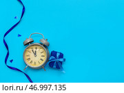 Будильник с подарочной коробкой и лентой на фоне голубого цвета. Стоковое фото, фотограф Pixel_shot / Фотобанк Лори
