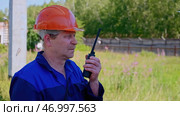 Portrait of mature construction superintendent using transmitter for talking to workers. Стоковое фото, фотограф David Kashakhi / Фотобанк Лори