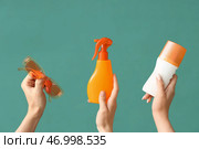 Женские руки с бутылками крема для солнцезащиты и солнечные очки на зеленом фоне. Стоковое фото, фотограф Pixel_shot / Фотобанк Лори