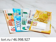 Российские деньги. Купюры 100 рублей, 500 рублей, 1000 рублей, 2000 рублей, 5000 рублей лежат на столе. Стоковое фото, фотограф Константин Козлов / Фотобанк Лори