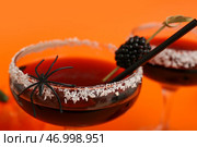 Стакан вкусного коктейля для Хэллоуина с ежевикой и пауком на оранжевом фоне, крупным планом. Стоковое фото, фотограф Pixel_shot / Фотобанк Лори