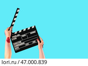 Руки зомби, держащие кинематографический хлопушка на синем фоне. Празднование Хэллоуина. Стоковое фото, фотограф Pixel_shot / Фотобанк Лори