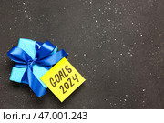 Стреляющая записка с целями на 2024 год и подарочная коробка на грубом черном фоне. Стоковое фото, фотограф Pixel_shot / Фотобанк Лори