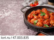 Жареная сковорода с вкусными фрикадельками в томатном соусе и петрушкой на сером фоне. Стоковое фото, фотограф Pixel_shot / Фотобанк Лори