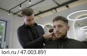 Experience an exceptional Barber Styling Haircut in a sophisticated and modern salon today. Стоковое фото, фотограф David Kashakhi / Фотобанк Лори