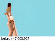 Женщина с тональным кремом и губкой для макияжа на голубом фоне. Стоковое фото, фотограф Pixel_shot / Фотобанк Лори
