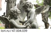A video showcases cherubic statues in tranquil settings, inviting peace. Стоковое фото, фотограф David Kashakhi / Фотобанк Лори