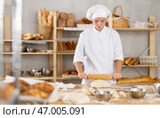 Adolescence girl baker works with rolling pin, rolls out and spreads out pieces of dough. Стоковое фото, фотограф Яков Филимонов / Фотобанк Лори