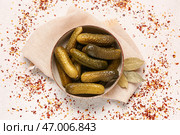 Миска вкусных маринованных огурцов с лавровыми листьями и специями на белом фоне. Стоковое фото, фотограф Pixel_shot / Фотобанк Лори