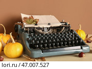 Винтажная пишущая машинка, тыквы, каштаны и осенние листья на коричневом фоне. Стоковое фото, фотограф Pixel_shot / Фотобанк Лори