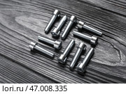 Болты с шестигранной головкой на сером деревянном фоне, крупным планом. Стоковое фото, фотограф Pixel_shot / Фотобанк Лори