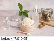 Миска с маслом ши, орехами и косметическими продуктами на светлом столе. Стоковое фото, фотограф Pixel_shot / Фотобанк Лори