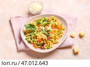 Тарелка с вкусной пастой примавера и сыром на бежевом фоне. Стоковое фото, фотограф Pixel_shot / Фотобанк Лори