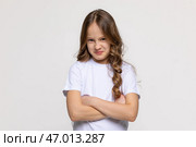 Negative human emotions, reactions and feelings. Isolated shot of moody displeased angry little girl crossing arms on her chest, pouting lips, having offended facial expression, being capricious. Стоковое фото, фотограф Ирина Михайличенко / Фотобанк Лори