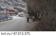 Mountain road with overhanging rocks and shops for tourists. Стоковое фото, фотограф David Kashakhi / Фотобанк Лори