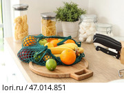 Сетчатая сумка с фруктами на кухонной доске. Стоковое фото, фотограф Pixel_shot / Фотобанк Лори