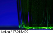 Pouring soft drink, green soda inside glass Isolated on a blue background. Стоковое фото, фотограф David Kashakhi / Фотобанк Лори