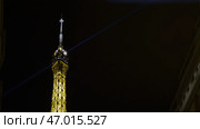 Low angle view of a shining illuminating tower on the night sky background. Стоковое фото, фотограф David Kashakhi / Фотобанк Лори