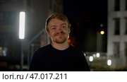 A night portrait with lanterns and a man with stubble who laughs and poses. Стоковое фото, фотограф David Kashakhi / Фотобанк Лори