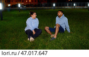A green glade with sitting lovers who talk and gesticulate. Стоковое фото, фотограф David Kashakhi / Фотобанк Лори