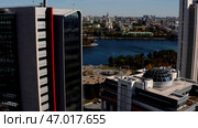Tall buildings located on the river bank in the city center with overgrown trees. Стоковое фото, фотограф David Kashakhi / Фотобанк Лори