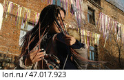 Woman shows off beautiful dreadlocks in colorful hairstyles at city's street festival. Стоковое фото, фотограф David Kashakhi / Фотобанк Лори