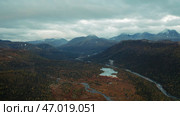 Aerial flight over amazing small lake surrounded by forested valley and mountains. Стоковое фото, фотограф David Kashakhi / Фотобанк Лори