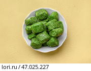 Чаша с замороженным шпинатом на цветном фоне. Стоковое фото, фотограф Pixel_shot / Фотобанк Лори