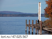 Serene seaside scene featuring a fisherman on a rustic pier in Norway (2016 год). Редакционное фото, фотограф EugeneSergeev / Фотобанк Лори