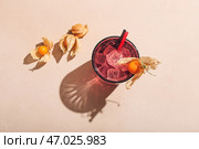 Стакан вкусного коктейля с физалисом на цветном фоне. Стоковое фото, фотограф Pixel_shot / Фотобанк Лори